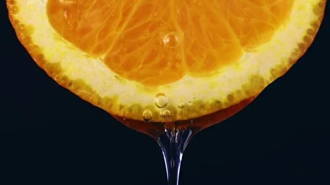 Transparent gel flowing down from bright orange slice Stock Footage 268873923