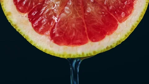 Transparent gel flowing down from bright red grapefruit slice Stock Footage 273572401