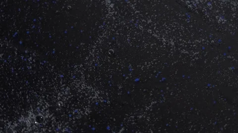 Transparent gel texture with blue balls and bubbles rotating on a black surface Stock Footage 252195432