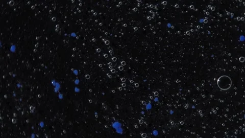 Transparent gel texture with blue balls and bubbles rotating on a black surface Stock Footage 252195510