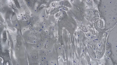Transparent gel texture with blue balls flowing down Stock Footage 252195643