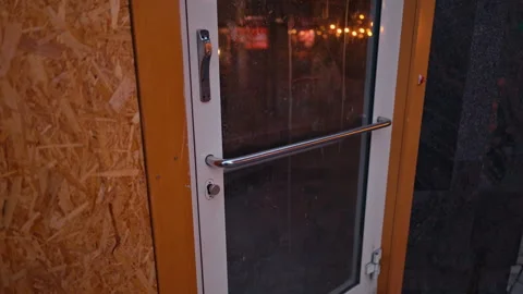 A Transparent Glass Door Featuring a Metallic Handle Set in an Urban Environment Vidéo 314316360
