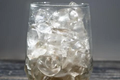 Transparent glass with ice cubes on the table. Drink and refreshment concept Stock Photos