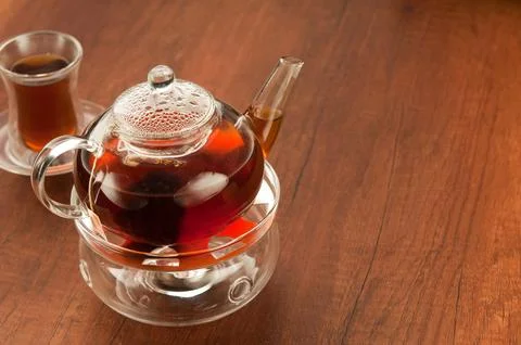 Transparent glass teapot and cup with tea Stock Photos