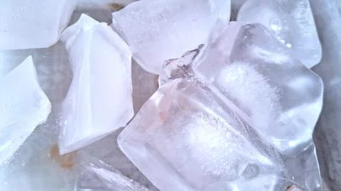 Transparent ice cubes resting together in a bright white setting 写真素材