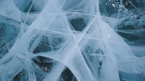 Transparent ice of lake Baikal with a pattern of cracks Stock Photos
