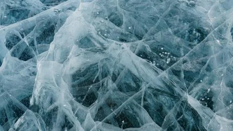 Transparent ice of lake Baikal with a pattern of cracks Stock Photos