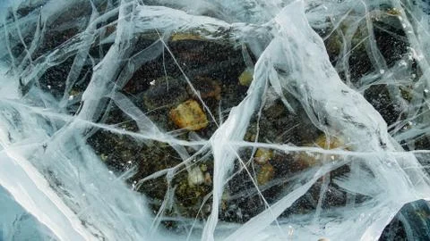 Transparent ice of lake Baikal with a pattern of cracks Stock Photos