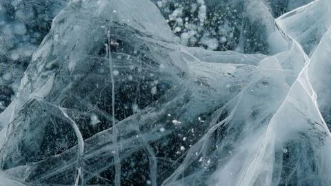 Transparent ice of lake Baikal with a pattern of cracks Stock Photos