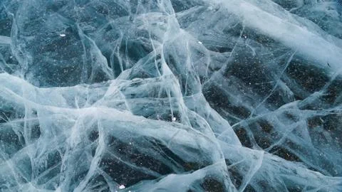 Transparent ice of lake Baikal with a pattern of cracks Stock Photos
