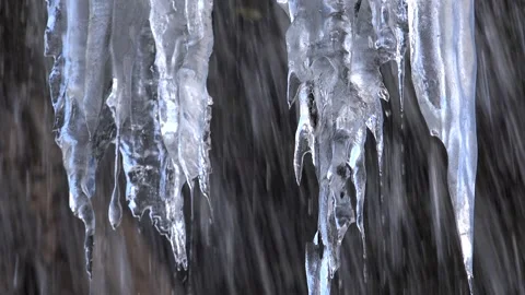 Transparent icicles hang beside a winter waterfall - Ice Pattern and Icy Water 库存影片 339375677