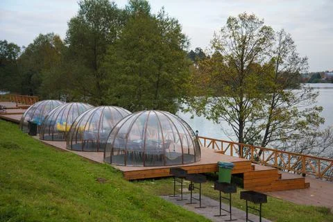 Transparent igloo-shaped hemispheres. Transparent gazebos stand on the river Stock Photos