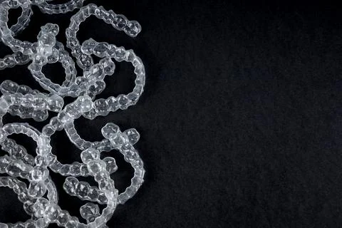 Transparent invisalign retainers brackets on black background. Dental Stock Photos