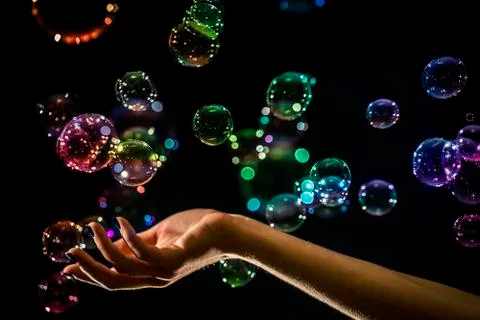 The transparent, iridescent soap bubbles isolated on black. Stock Photos