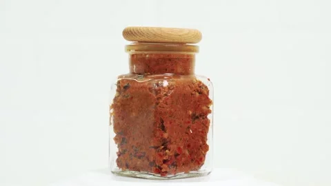 A transparent jar of adjika rotates on a turntable Stock Footage 253317277