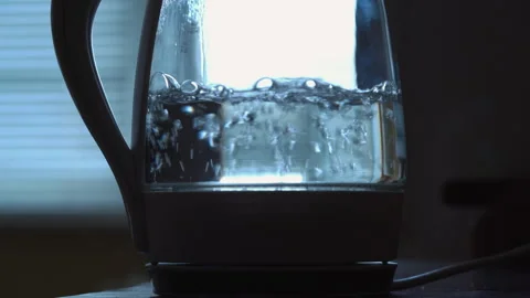 Transparent kettle with boiling water on the background of the window. Video stock 256203593