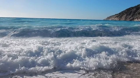 Transparent limpid turquoise sea with comber and white foam and blue sky. Stock-Footage 81282307
