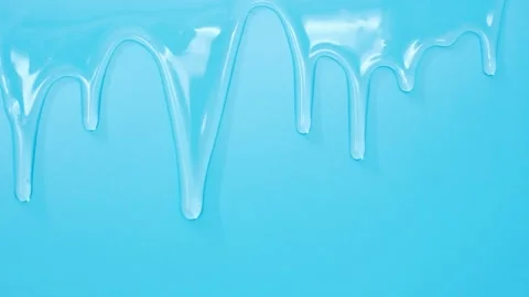 Transparent liquid collagen flowing down on blue background close-up. Stock Footage 195283257