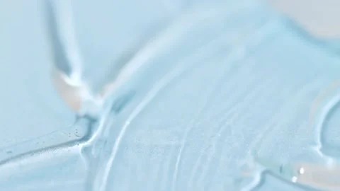 Transparent liquid cosmetic texture close-up on a blue background. Stock Footage 232371386