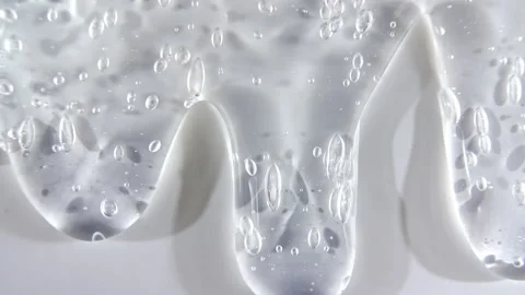 Transparent liquid gel cream with micro Bubbles as it slowly slides down. Macro Stock-Footage 143532380