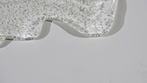 Transparent liquid gel cream with micro Bubbles as it slowly slides down. Macro Stock Footage 145142408