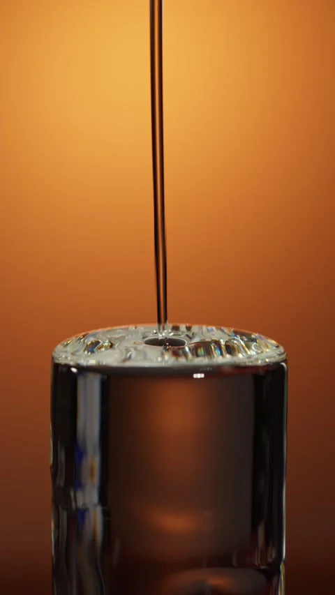 Transparent liquid injected into abstract cylindrical glass column macro 스톡 동영상 341452656