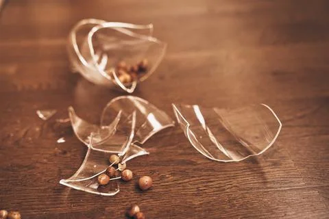 Transparent mug broken close-up of compote with raisins. Pieces of broken glass Stock Photos