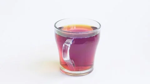 Transparent mug of strong brewed tea spins in a circle on a white backgroun.. 库存影片 289882596