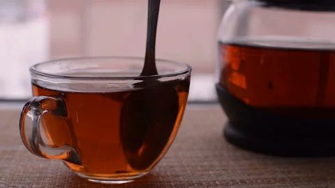 Transparent mug of tea. Spoon stir the tea. Traditional tea party. Vídeos de archivo 103599746