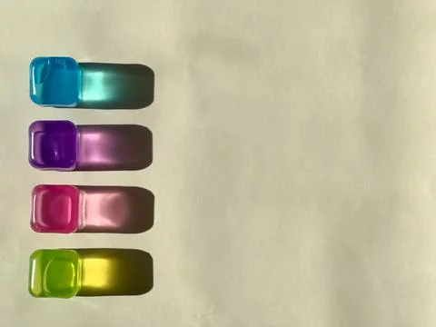 Transparent multicoloured plastic ice cubes. Coloured bright shadows Foto stock