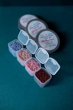 Transparent open boxes with beads on a plain background Stock Photos