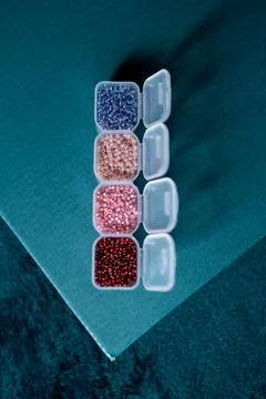 Transparent open boxes with beads on a plain background Stock Photos