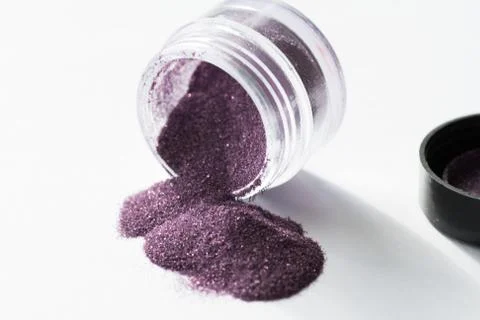 Transparent packaging jar purple sequin open on white background macro Stock Photos