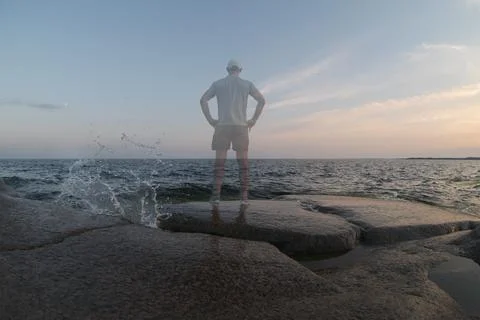A transparent person stands on the seashore. Back view Stock Photos