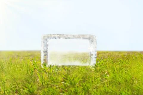 Transparent piece of melting ice on the green grass Stock Photos