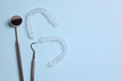 Transparent plastic aligners and dentist's tools on a colored background Foto stock