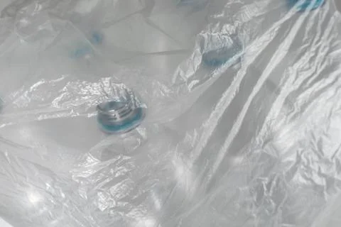 Transparent plastic bag with several empty plastic bottles inside on a white  Foto stock