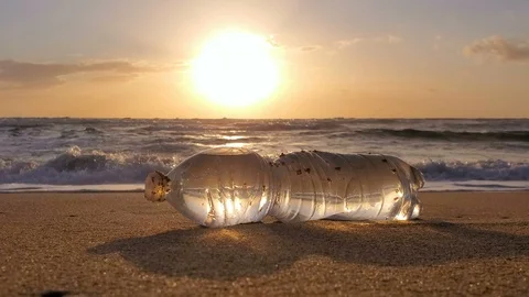 Transparent Plastic bottle on sandy sea shore motion sunset,polluted nature 4k Stock Footage 125483852