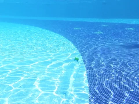 Transparent plastic bottle slowly sinking in pool water Stock Footage 105101428