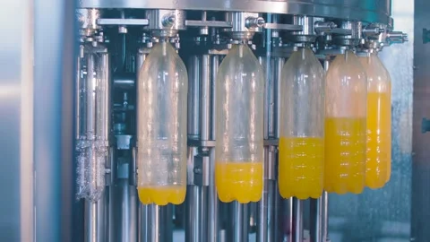 Transparent plastic bottles move on conveyor belt and filled of juice Stock-Footage 131843704