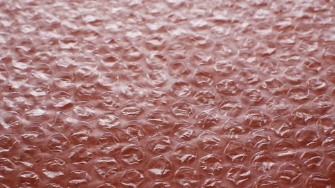 Transparent plastic bubble wrap packing tape on an orange background Stock Footage 128827395