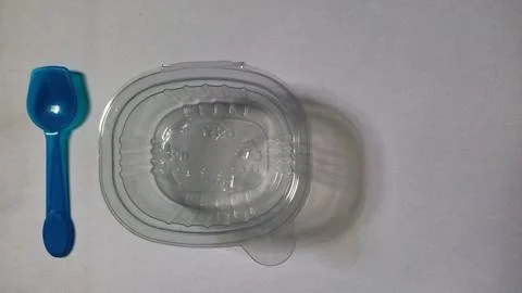Transparent plastic container with blue plastic spoon Stock Photos
