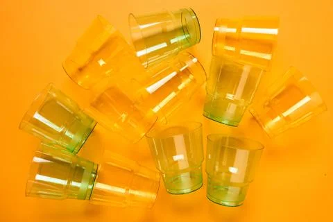 Transparent Plastic Cups On Orange Background Stock Photos