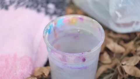 Transparent plastic glass of water mudded by brushes Stock Footage 123655686