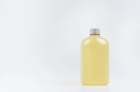 Transparent plastic low thick bottle with orange drink, cooking oil or cosmet Stock Photos
