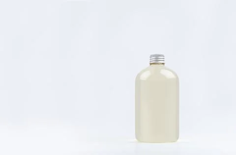 Transparent plastic low thick bottle with pale fresh drink or cosmetic essent Stock Photos