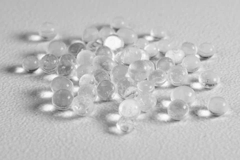 Transparent Plastic Pellets on White Surface Stock Photos