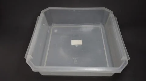 Transparent Plastic Storage Box in square shape, black background. Stock Photos