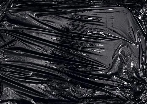 A transparent plastic wrap on black background Stock Photos