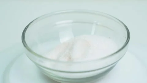 A transparent plate with white table salt is spinning on the turntable Vidéo 253214498